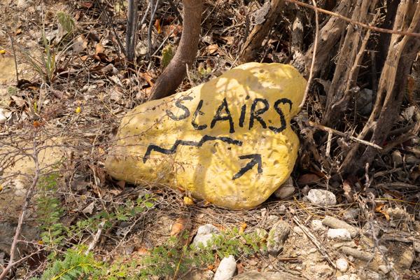Duikdelijk aangegeven met een gele steen vindt je de locatie van de trap.